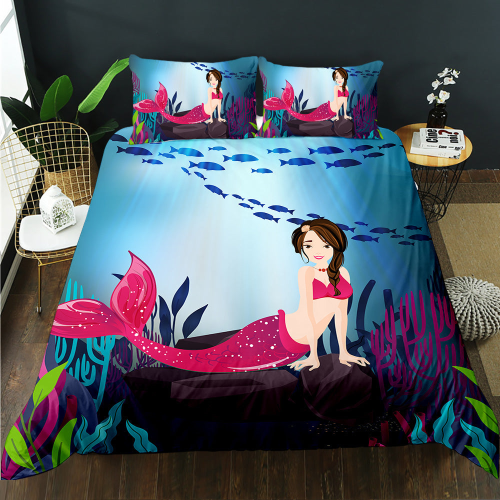 Mermaid-themed bedding set with pink tail and blue ocean design on a bed in a room.